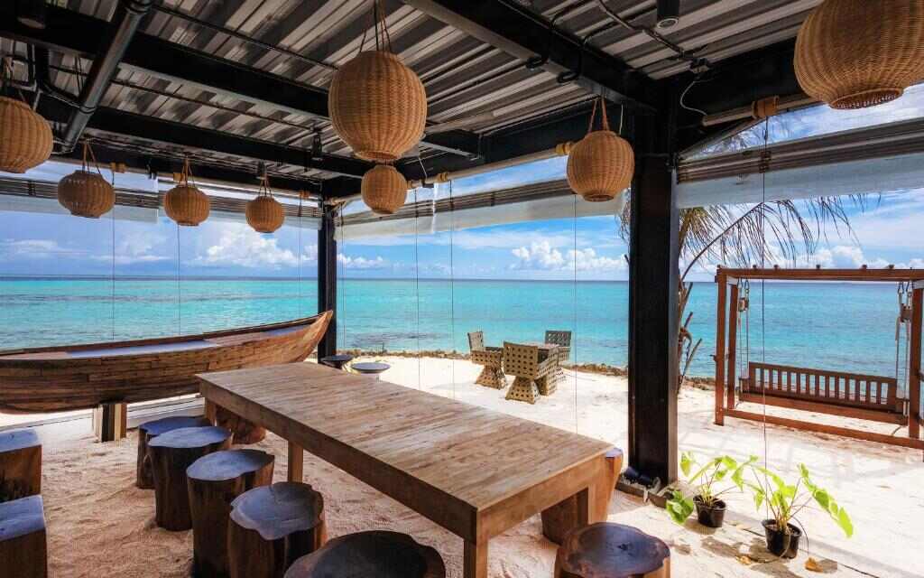 Long wooden dining table facing the lagoon